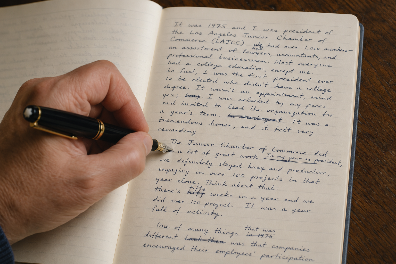 A hand writing in a journal with a fountain pen.